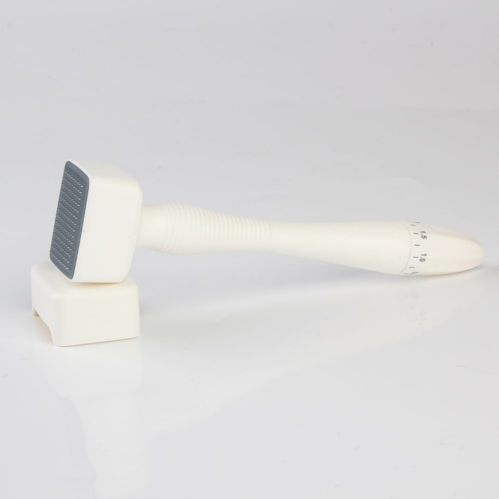 Derma Stamp tool at an angle, highlighting its ergonomic handle and compact design