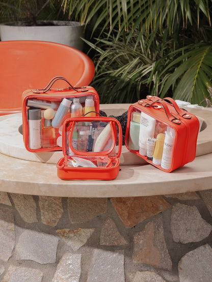 CALPAK orange clear makeup cases with zippered compartments in small, medium and large sizes; CCM2001-PAPAYA