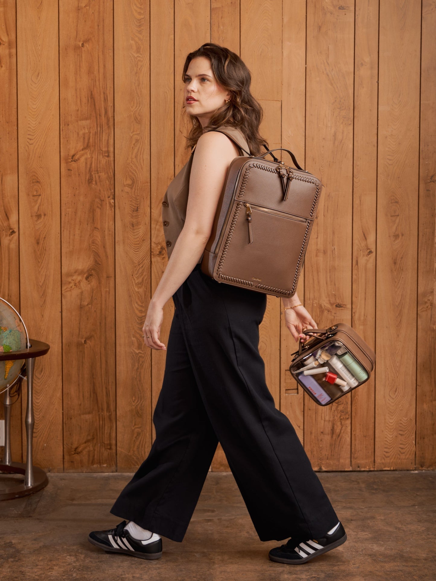 Model holding CALPAK medium clear makeup case with top handles in mocha; CMM2201-MOCHA