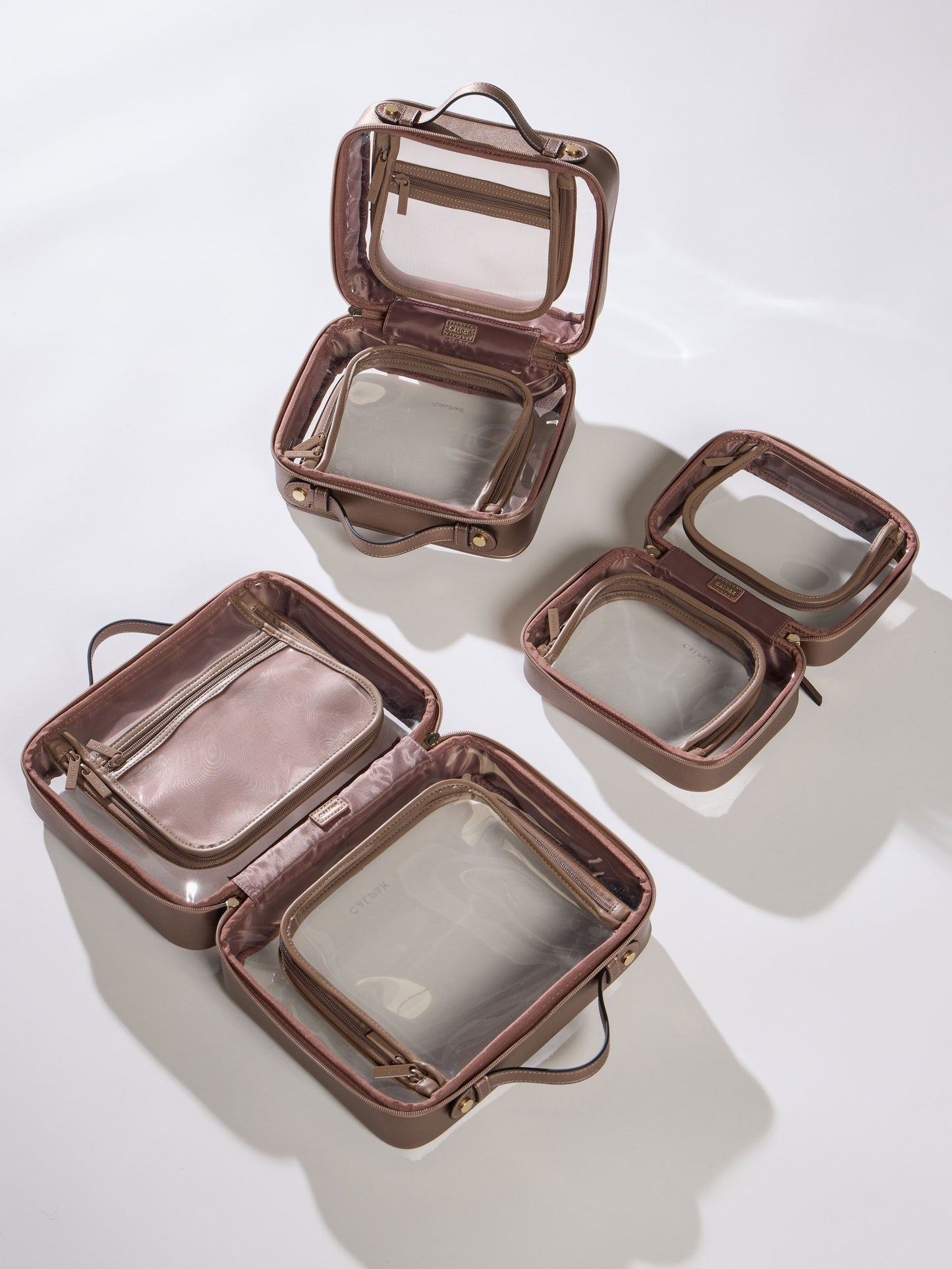 CALPAK Medium Clear Cosmetic Case, Large Clear Cosmetic Case and Small Clear Cosmetic Case in brown bronze; CMM2201-BRONZE