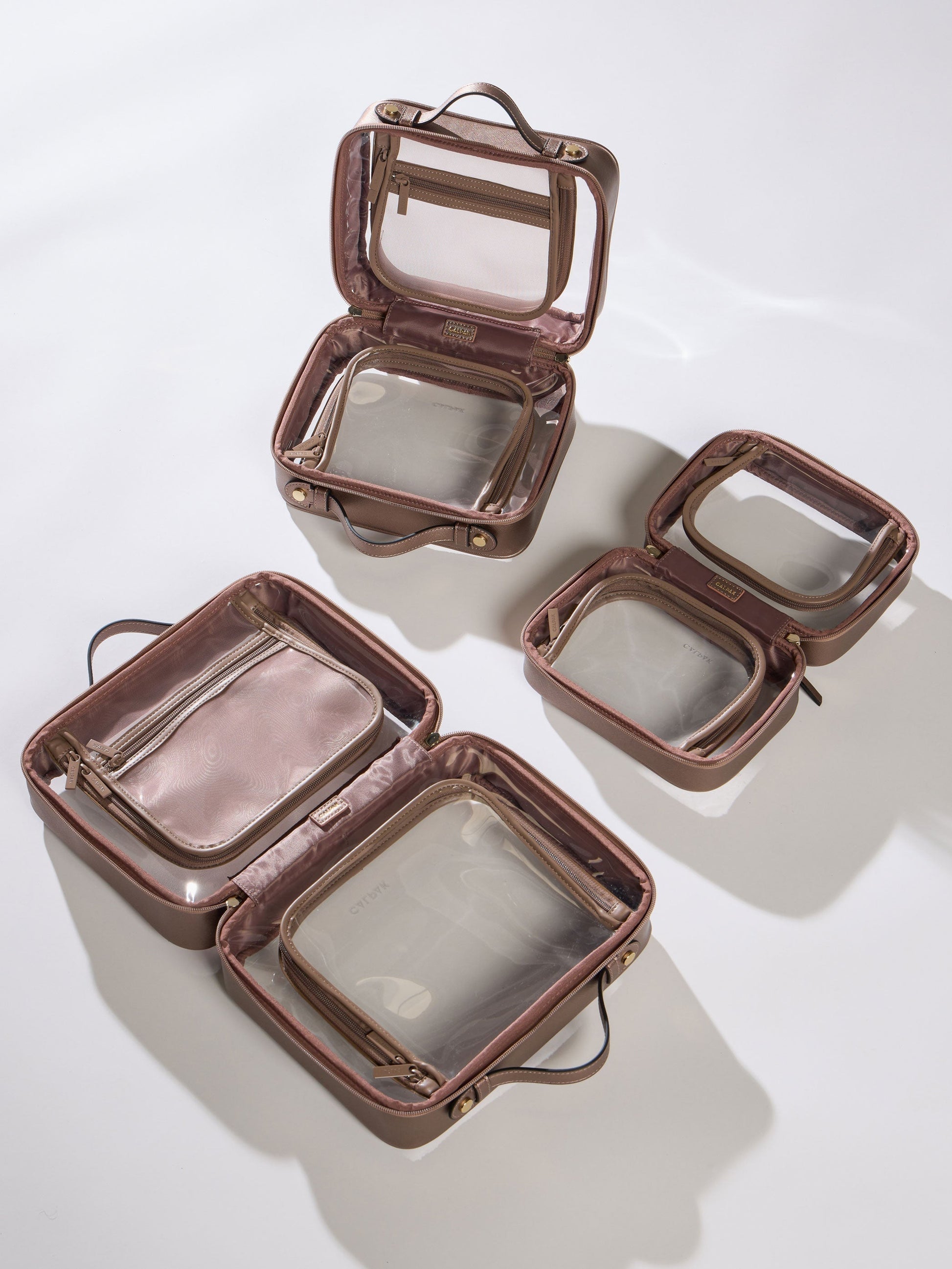 CALPAK Medium Clear Cosmetic Case, Large Clear Cosmetic Case and Small Clear Cosmetic Case in brown bronze; CMM2201-BRONZE