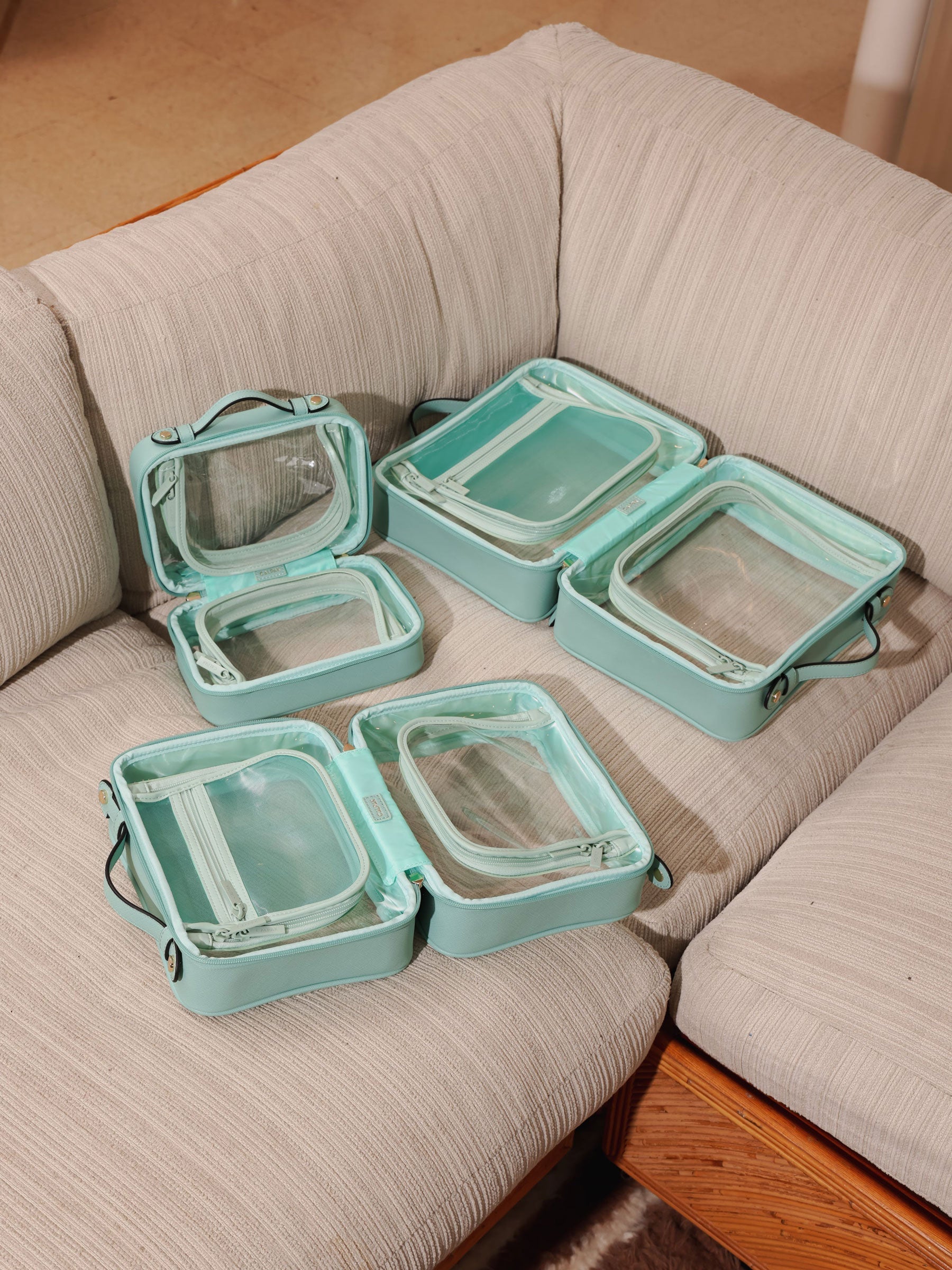 CALPAK aqua clear makeup cases with zippered compartments in small, medium and large sizes; CCM2001-AQUA