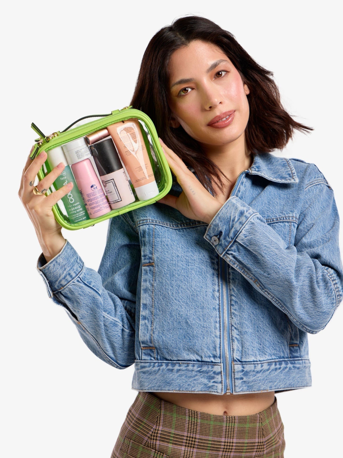Model holding up CALPAK small clear cosmetic case in bright green; CCM2001-ELECTRIC-LIME